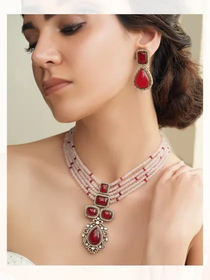 A bold necklace with a large ruby pendant on a string of pink beads, perfect for making a colorful statement.