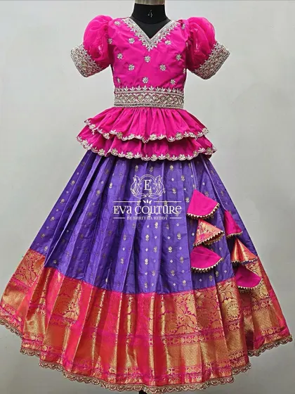 A similar tiered design with a ruffled peplum top. The bright pink blouse and purple skirt create a festive look, perfect for a little girl who loves to twirl.