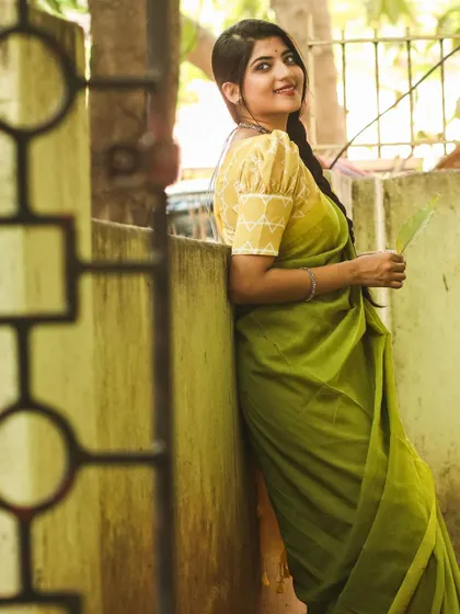 A playful and happy shot in a lime green summer cotton saree. The image captures a feeling of lightness and poetry, perfect for showcasing comfortable and breezy fabrics.