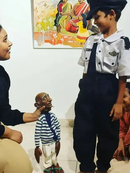 Our puppeteer introducing 'Popo' to a young boy in costume during a workshop at Tasmai Art Gallery.