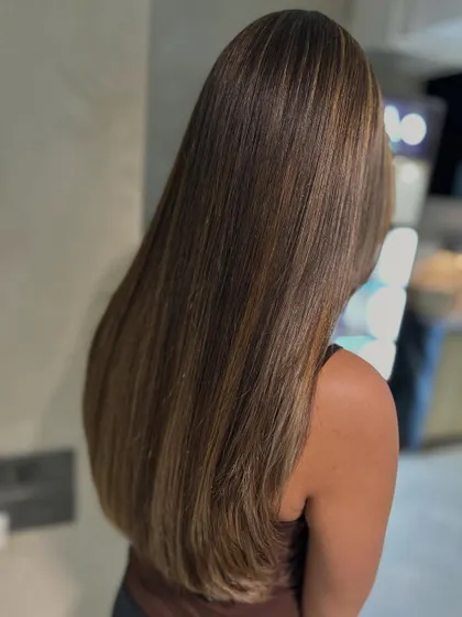 A cool blonde highlight blend on a classic one-length haircut. Styling the hair straight emphasizes the clean lines of the cut and the beautiful, blended color work.