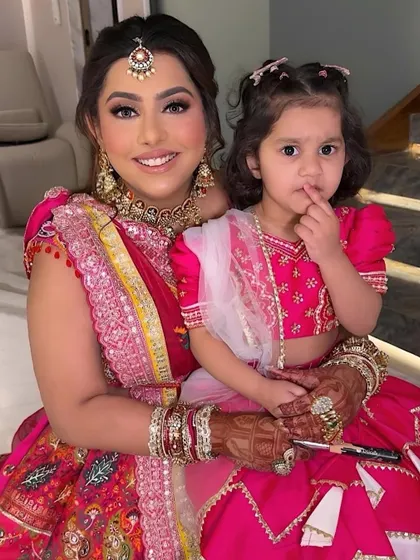 Mother and daughter, both looking absolutely adorable in their matching pink outfits.