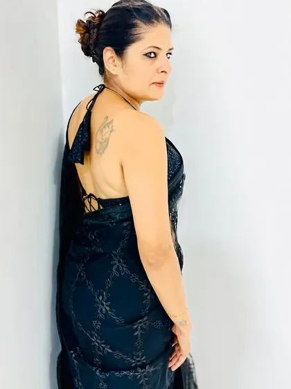 A black saree with delicate embroidery, paired with a bold backless halter-neck blouse. This is a perfect example of my signature 'sultry yet sophisticated' style.