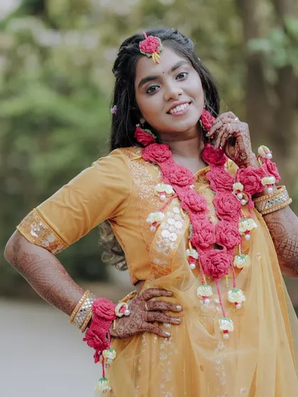 A happy portrait of the bride posing confidently in her yellow Haldi outfit.