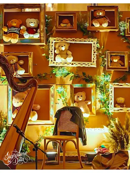 A creative photo wall featuring framed teddy bears, with a harp in the foreground to provide live, elegant music, enhancing the sophisticated atmosphere.