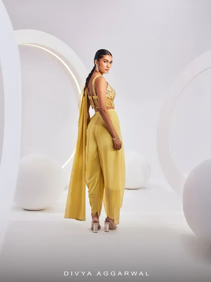The back view of our ISLA Saree Set, showing the unique dhoti-style pre-draped saree and the detailed corset blouse in a cheerful yellow.