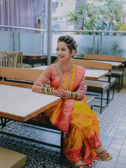 A relaxed, seated portrait of the bride, looking radiant and happy in her traditional attire.