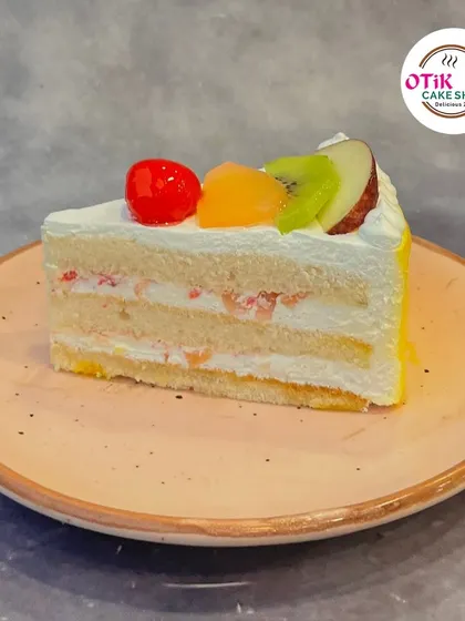 Our Fresh Fruit Pastry is a light and refreshing choice. This slice features layers of vanilla sponge, fresh cream, and a mix of seasonal fruits, offering a taste of pure, simple goodness.