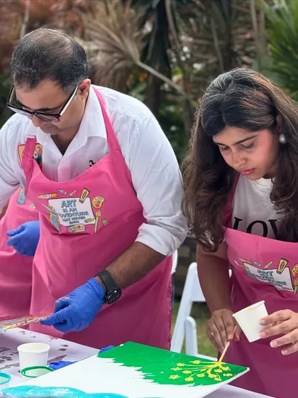 Parents getting in on the fluid art fun at their child's birthday party. Our events are designed for everyone to enjoy, making for a truly collaborative and memorable celebration.