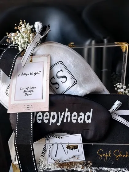 A "Sleepyhead" hamper for the bride, featuring a personalized eye mask and custom monogrammed towels in a clear acrylic box.