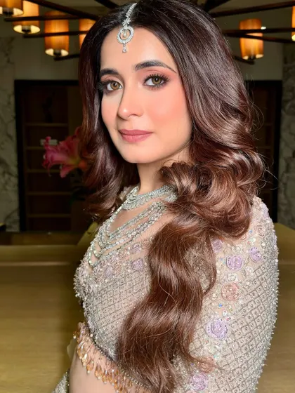 A close-up of this exotic and elegant reception look. The eye makeup is soft and blended, with a focus on creating a warm, romantic gaze.