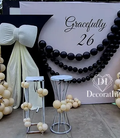 The elegant black and white setup, with the pearl-like balloon garland beautifully draping across the custom backdrop.