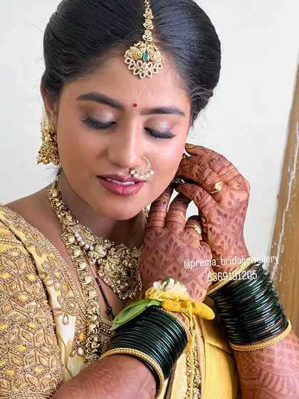 A detailed shot of the bride's hands, showcasing the henna, bangles, and the beautiful earrings from the rental set.