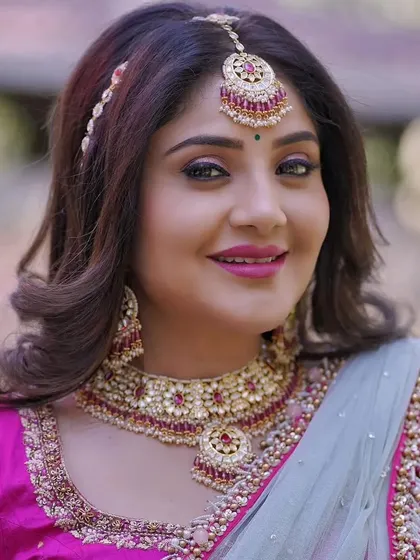 This client is wearing a beautiful Kundan set with pink stones for her event. The matching maang tikka and sheeshpatti complete her half-saree or lehenga look.