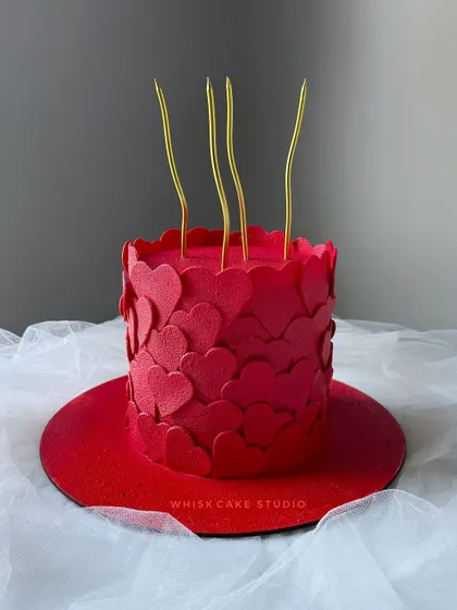 A simple yet striking anniversary cake. This all-red, fondant-covered cake is decorated with a cascade of edible hearts, making a bold statement of love.