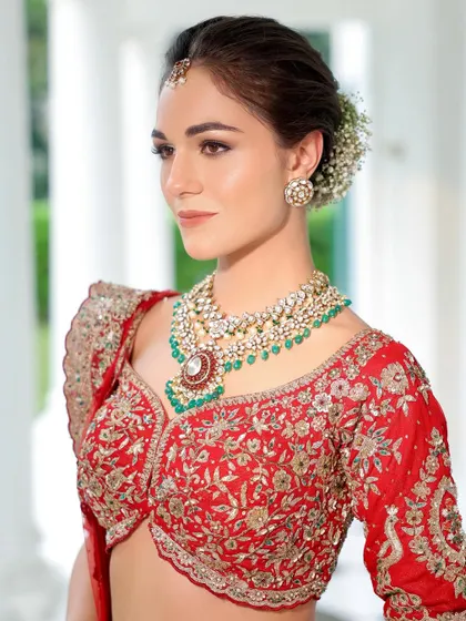 A classic portrait of our bride in red. The soft smokey eye and nude lip combination is a timeless choice that pairs perfectly with the ornate jewellery and red lehenga.