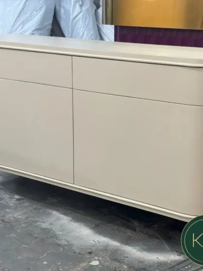 A standalone console table with a smooth, off-white lacquer finish and curved edges. This piece exemplifies modern minimalism, designed to add a touch of quiet sophistication and texture to an entryway or living room.