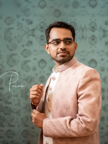 A close-up portrait of the groom, Pawan, adjusting his sleeve. This candid detail shot adds a touch of personality to his portrait session.