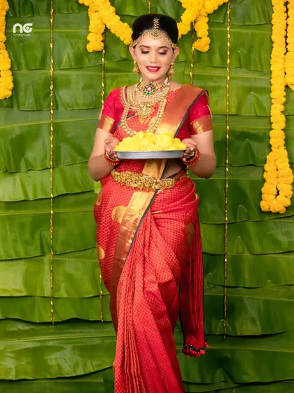 A festive look, with the model holding a plate of laddus against a traditional banana leaf backdrop.