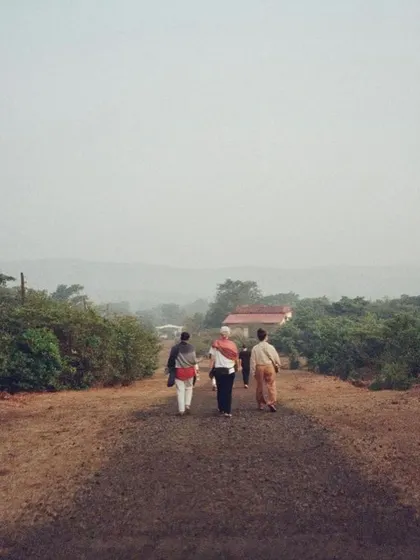Students and teachers walking along the simple path towards the ashram in Amboli. The journey here is both physical and spiritual, leading to a place of profound learning.