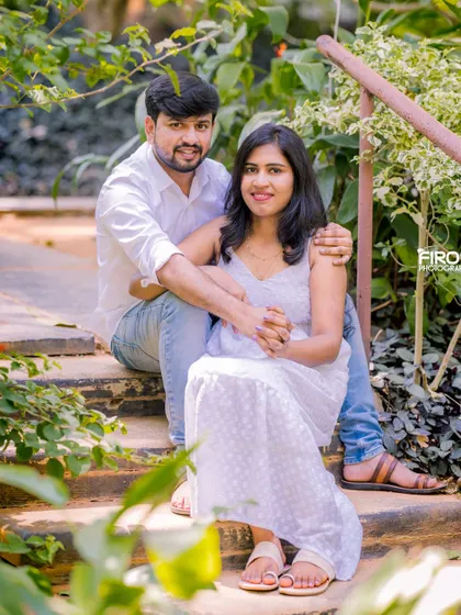 A sweet, seated portrait on garden steps. The couple's casual white and denim outfits and their close embrace create a very intimate and relaxed feel.