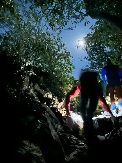 Climbing up a rocky patch at night, guided by the moonlight and headlamps. The Ratangad trek involves some easy but exciting scrambling sections.