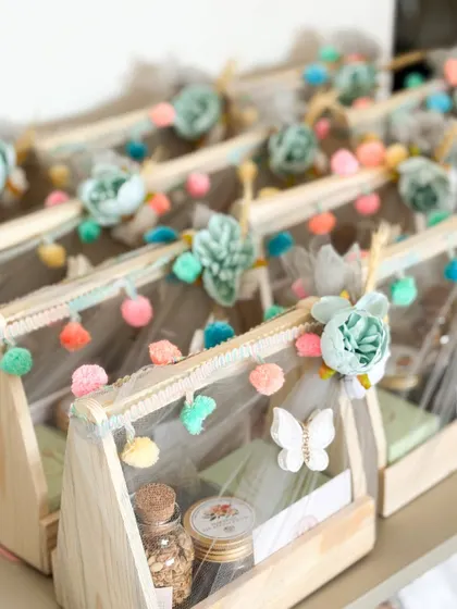 Welcoming a little man! This charming wooden hamper, decorated with playful pompoms and butterflies, is filled with healthy treats to celebrate the new arrival.