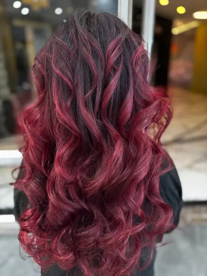 The back view of this red-violet balayage shows the beautiful blend of dark roots and vibrant ends.