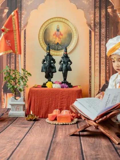 A quiet, studious moment as the baby looks at a holy book. This pose adds a serene and thoughtful dimension to the 'Chota Varkari' themed baby shoot.