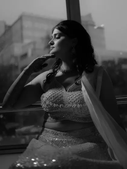 A beautiful black and white portrait by the window, capturing the bride's elegant profile and the soft light.