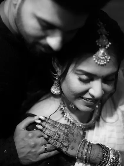 A tender black and white portrait of a newly engaged couple. This close-up focuses on their connection and the beautiful details of the bride's henna and jewelry.