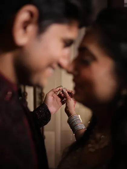 A soft-focus, romantic shot of a couple about to exchange their engagement rings.