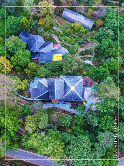 Our architectural work aims to harmonize with its surroundings. This aerial drone view shows the Blushing Pines Retreat in Bhowali, Uttarakhand, nestled seamlessly into the lush green hillside, demonstrating how thoughtful design can respect and enhance nature.