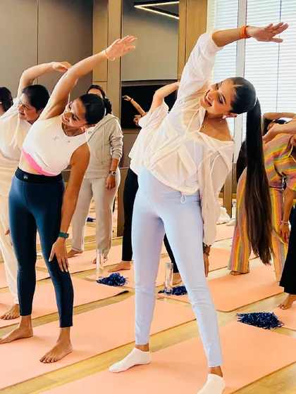 Joyful movement during a prenatal baby shower class, where friends and family join the mama-to-be for a session of gentle stretching and bonding.
