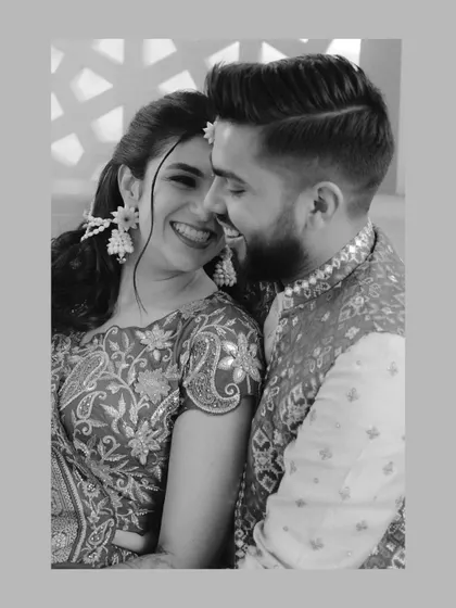 A black and white candid of the couple sharing a laugh during their Haldi. This intimate moment captures their easy chemistry and the joy of the celebration.