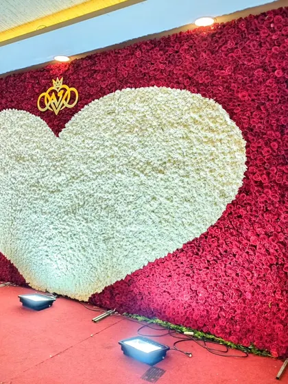 This statement photo backdrop features a giant heart made of white flowers set against a wall of rich red roses. It's a bold and romantic installation that provides a stunning photo opportunity for the couple and their guests.