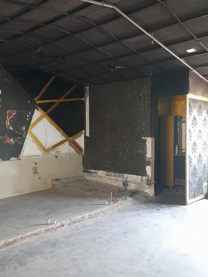 **BEFORE:** An empty, dark commercial unit with remnants of a previous design. The challenge was to transform this into a bright and functional retail space.