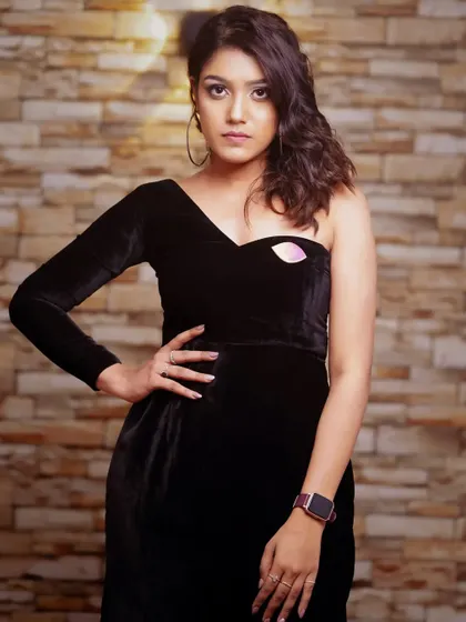 A modern and edgy portrait in a one-shoulder black dress. The brick wall background adds texture and an urban feel.