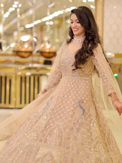 A joyful, twirling shot of the bride in her beige Anarkali, showing how the makeup looks beautiful in motion.