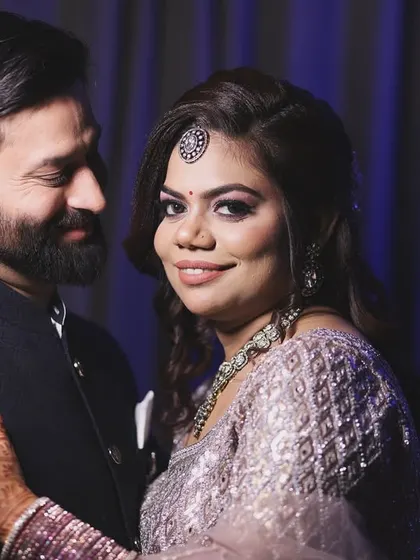 A tender moment between a couple, with the bride looking warmly at the camera. This portrait captures a feeling of comfort and togetherness.