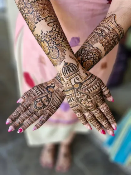 A full view of the custom bridal mehendi, combining personal names and modern skylines with traditional peacock and lotus designs.