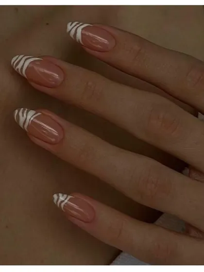 A subtle yet stylish animal print design. These almond-shaped nails feature a zebra print French tip, offering a modern and chic way to wear the trend.