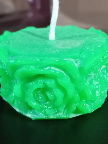 A detailed shot of my square rose candle. You can see the large rose design on the side, handcrafted from wax.