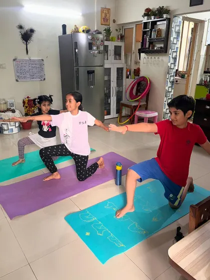 A duplicate of image 279, showing kids in a modified warrior pose, building strength and having fun.