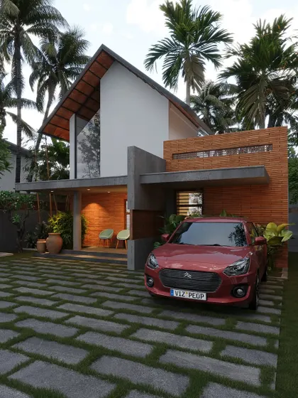 A beautiful home in Kasargod with a high, A-frame gabled roof and a facade combining white plaster with textured brick walls.