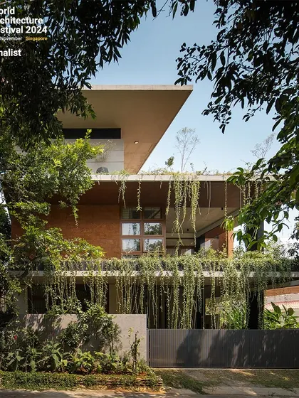 The front facade, where hanging vines and built-in planters soften the concrete structure, making the house a living entity.