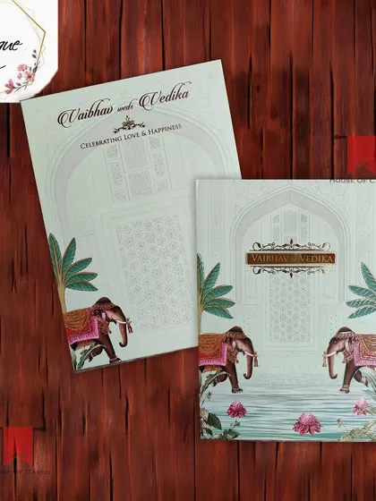 This pastel green invitation showcases decorated elephants and lotus ponds, blending traditional Rajasthani art with a soft, modern color scheme.