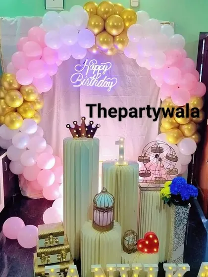 A pink and gold balloon arch with a 'Happy Birthday' neon sign, creating a classic and beautiful look.