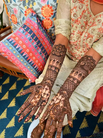 This design features rows of elephants and peacocks on the arms, with personalized portraits on the palms.