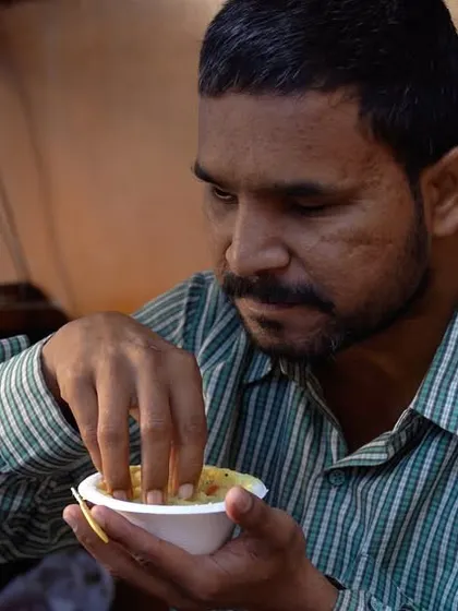 A man finds a moment of peace while eating a Sattvik meal. Join us in our mission to serve the underprivileged.